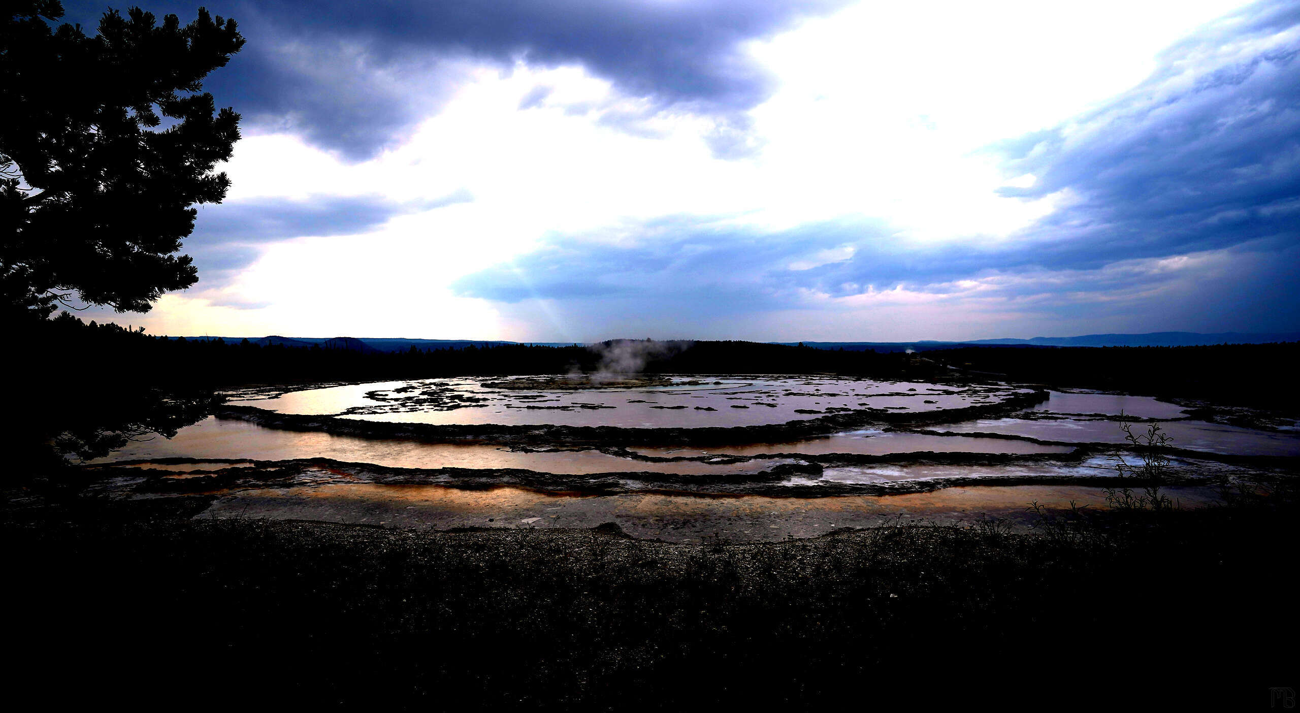 Arty Yellowstone hot spring under dark blue sky