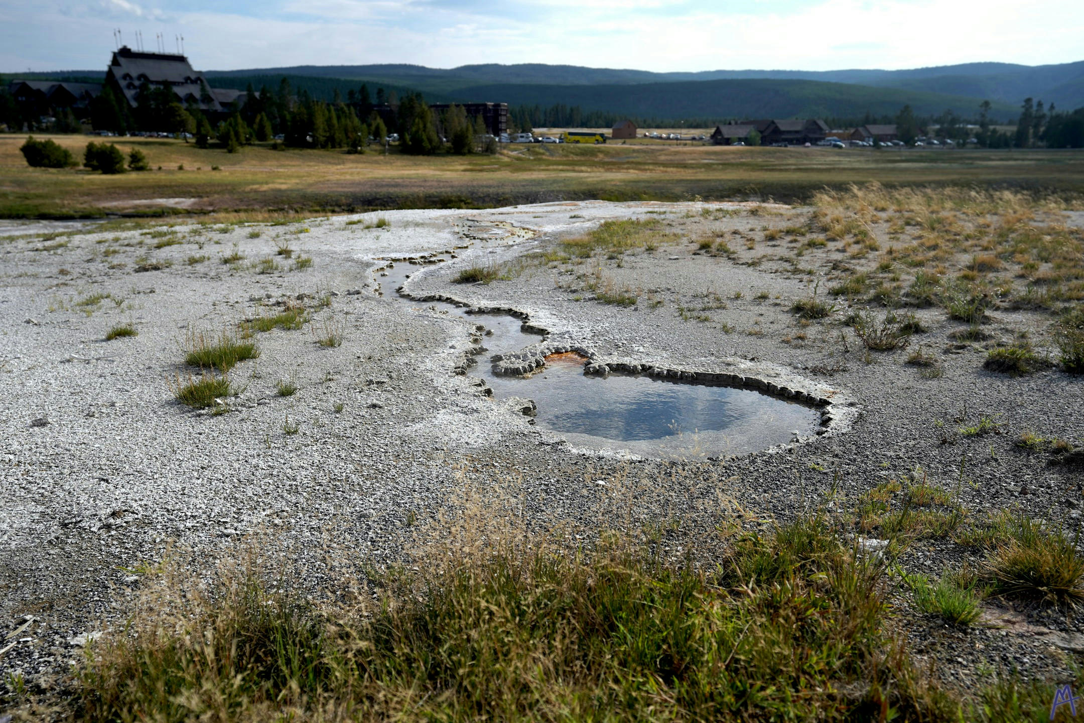 Small little hot spring with with trail with lodge at Yellowstone