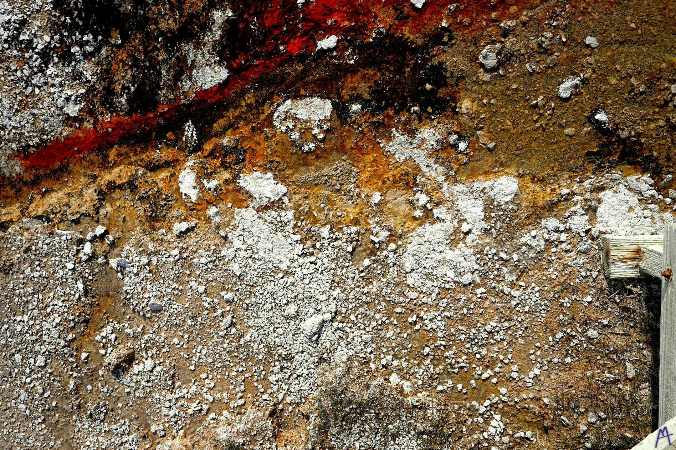 Orange and black white dirt near boardwalk at Yellowstone